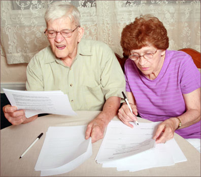 Confused older couple looking at forms